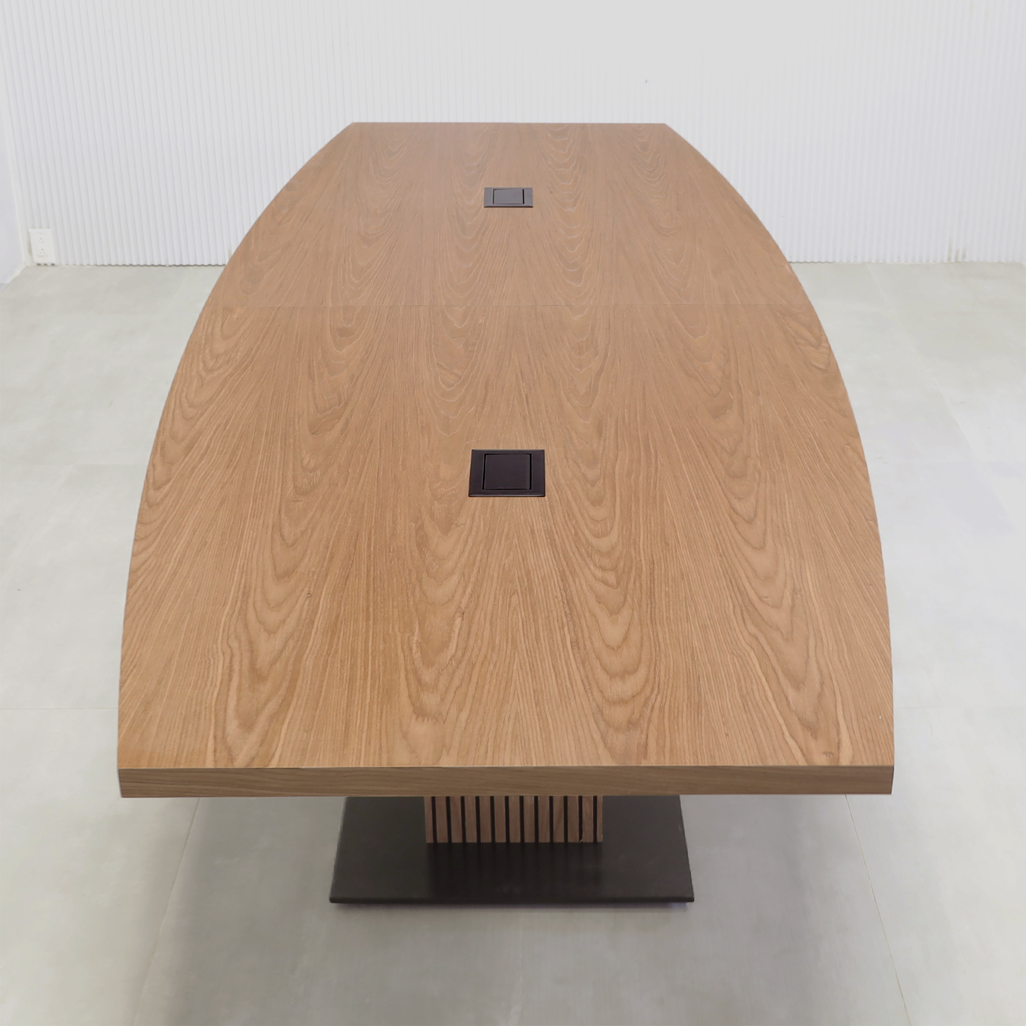 120-inch Newton Boat Conference Table with Laminate Top and X3 Base with walnut wood veneer top, walnut wood veneer tambour pedestal base, black matte laminate base, and mx2 power box in black.