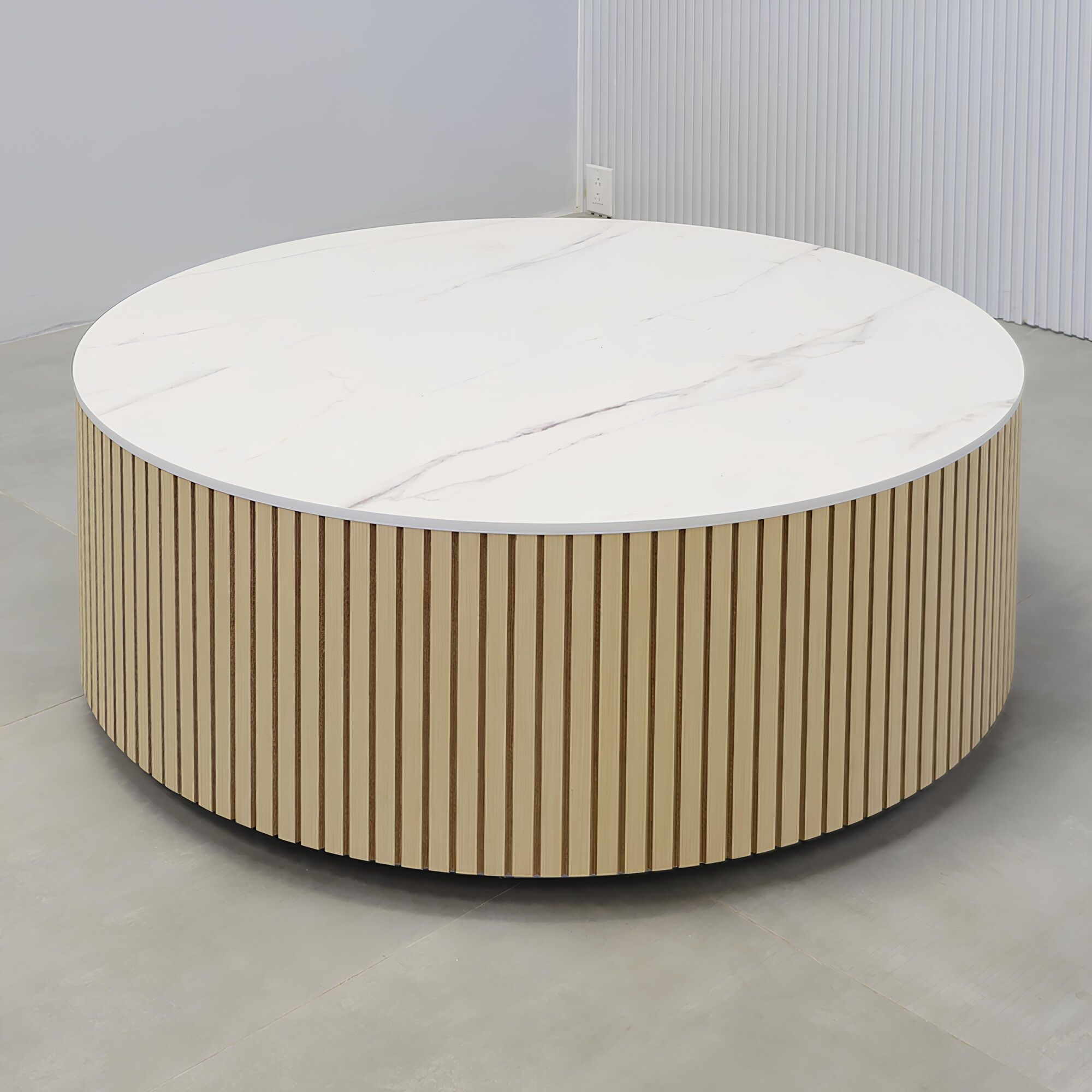 42-inch Norfolk Round Lobby Table with solenne marble engineered surface top, maple tambour table, and brushed aluminum toe-kick.