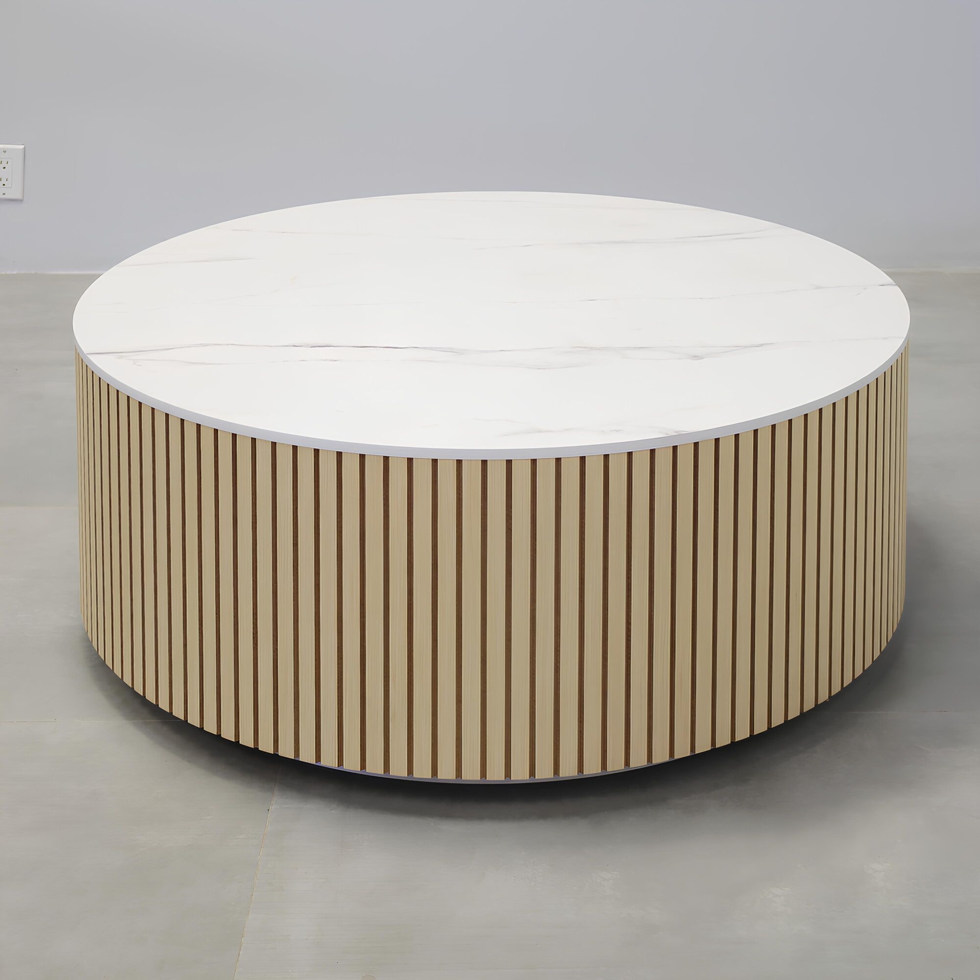 42-inch Norfolk Round Lobby Table with solenne marble engineered surface top, maple tambour table, and brushed aluminum toe-kick.