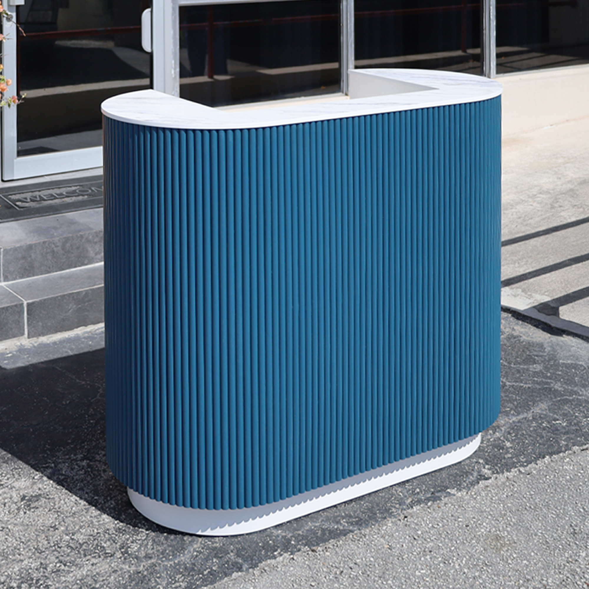 48-inch The Pill X2 Podium & Host Custom Desk with Dover Off-White matte laminate desk, and Sapphire CSP Benjamin Moore (Special Solid Wood Tambour Color). Calcutta Blanc engineered surface top, and Dover Off-White matte laminate toe-kick.