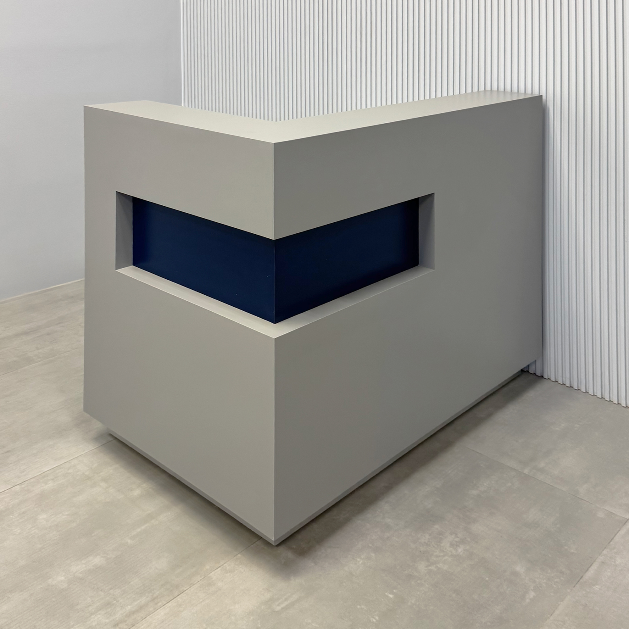 48-inch Manhattan L-Shape Reception Desk with Navy Blue matte laminate accent. Fog Gray matte laminate main desk. Brushed Aluminum toe-kick and Color LED.
