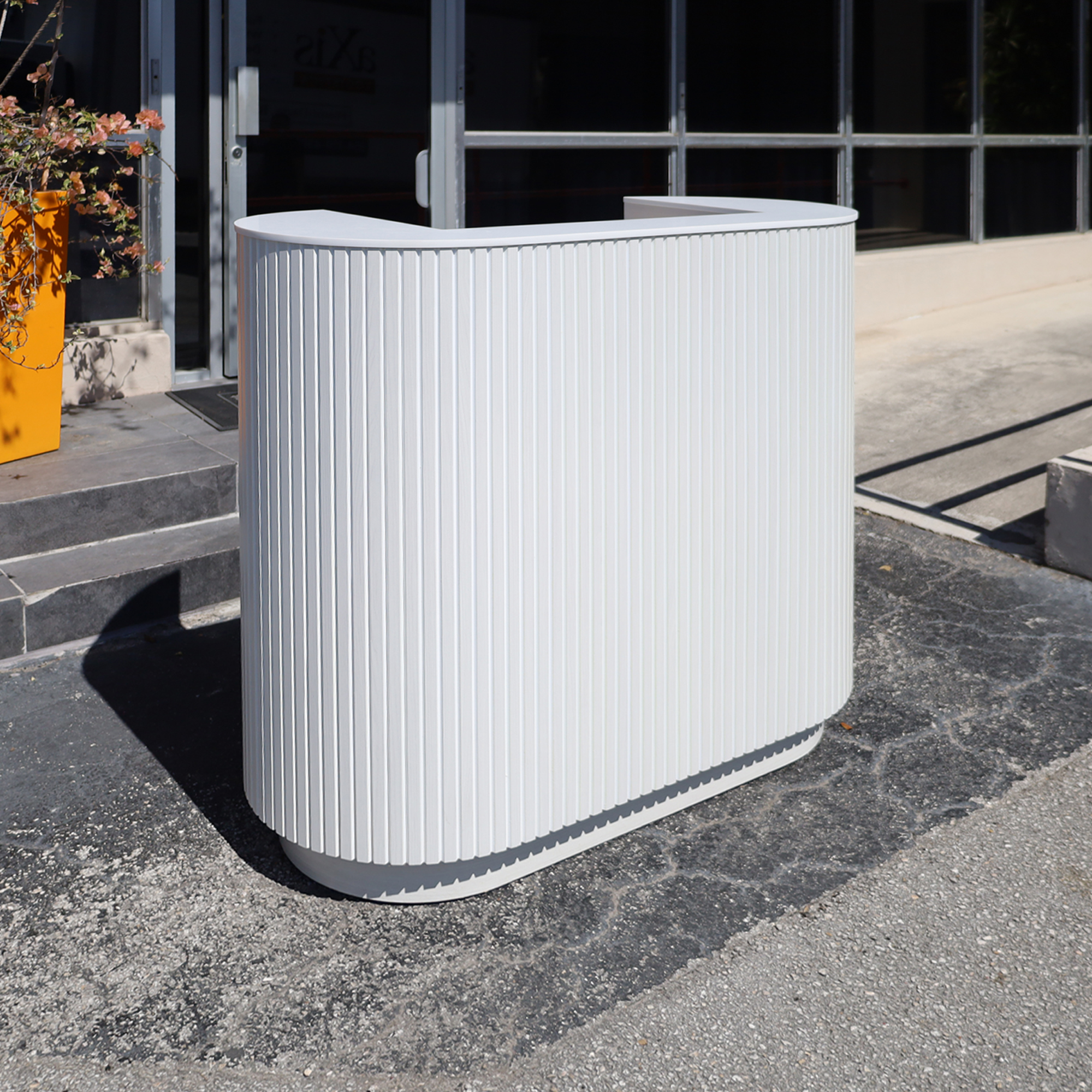 48-inch The Pill Podium Desk with White Ash tambour front, White Solid engineered surface top, White Ash matte laminate workspace, and toe-Kick.