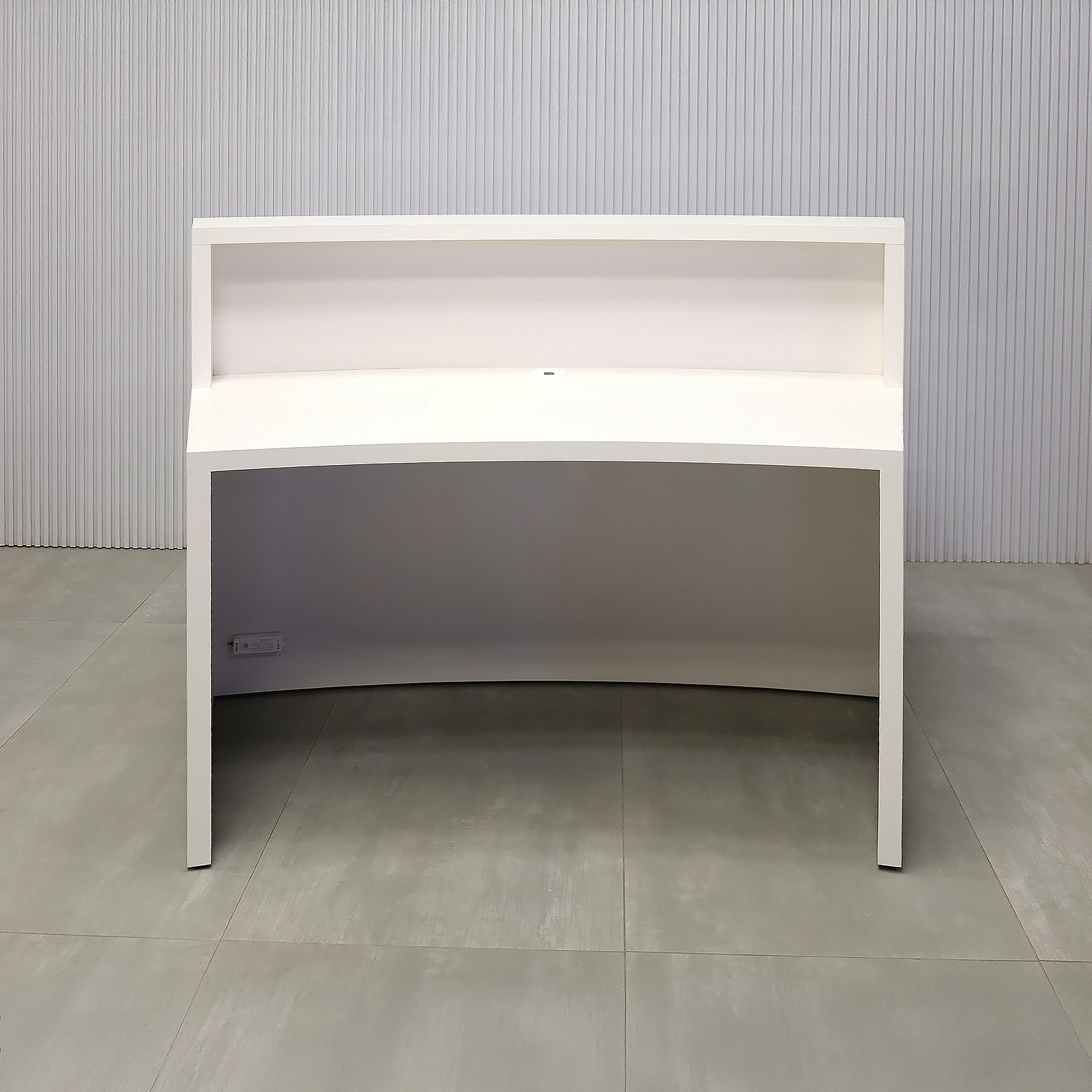 60-inch Seattle X2 Reception Desk with 413 Tumbled Glass engineered surface (Special Color) slats. Dover Off-White matte laminate counter & workspace. Spiced Chestnut matte laminate background and White LED with remote control.