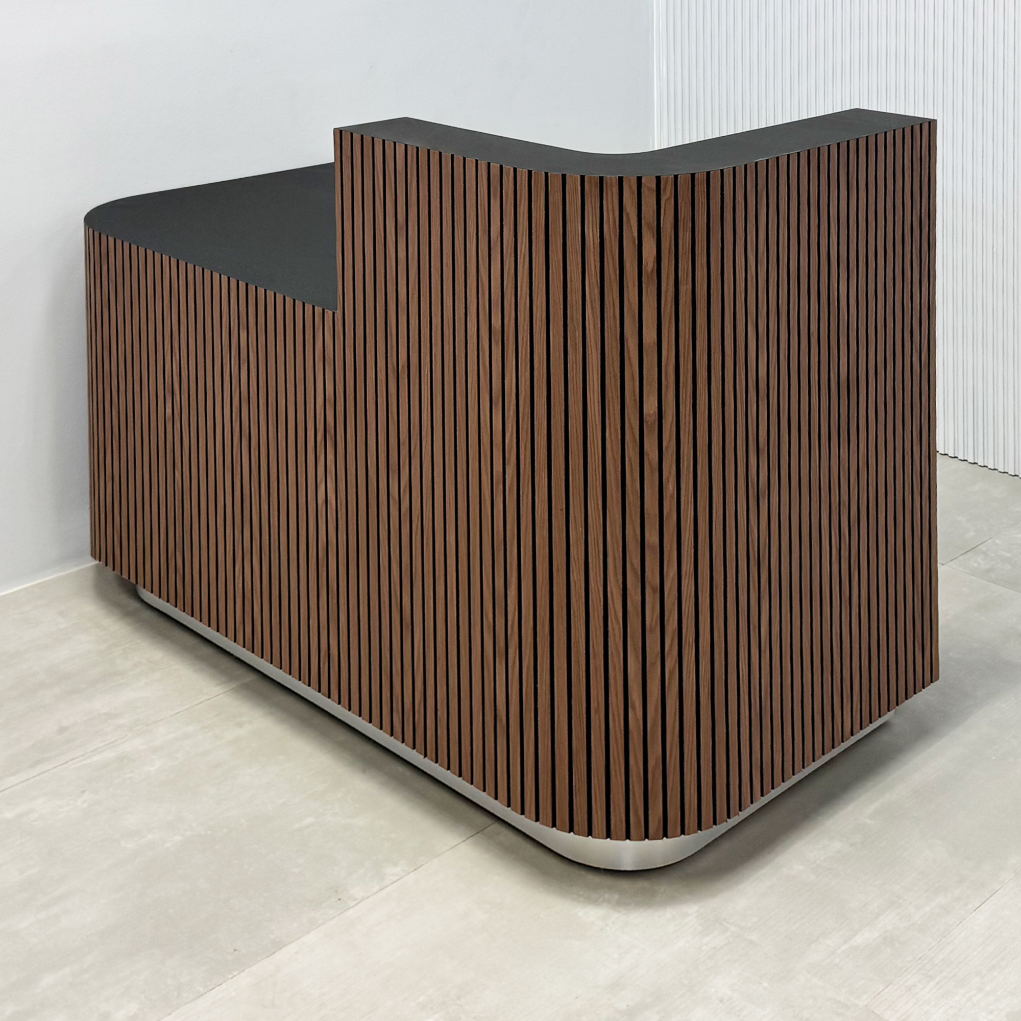 60-inch Nola Low Counter Reception Desk with Walnut & black background tambour desk, Black Traceless Laminate workspace & storage, and brushed aluminum toe-kick.