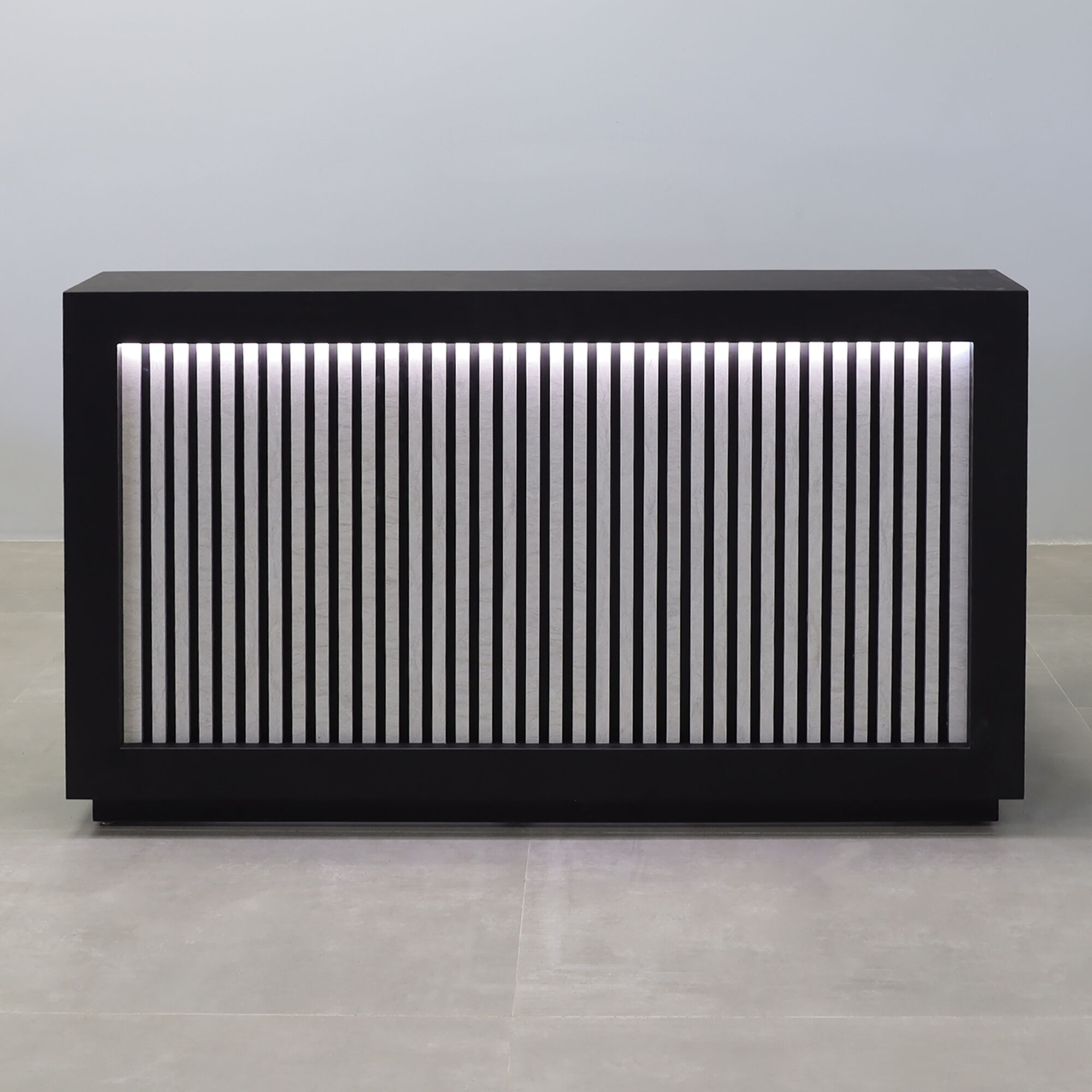 72-inch Vegas Designer Reception Desk in black traceless laminate main desk, spanish limestone engineered surface slats front panel, and warm white LED.