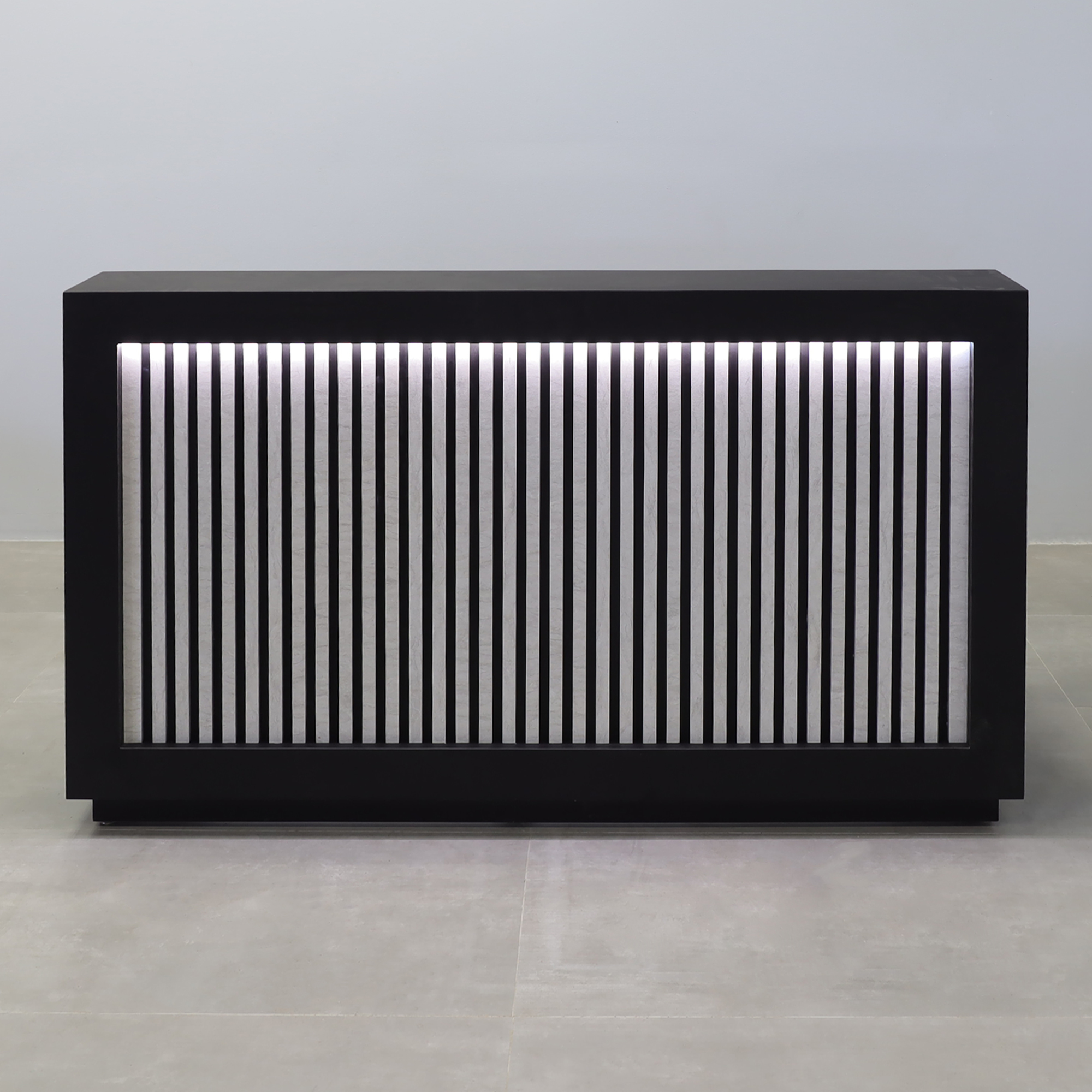 72-inch Vegas Designer Custom reception Desk with Black Traceless laminate main desk. Spanish Limestone slats front panel, warm white LED.