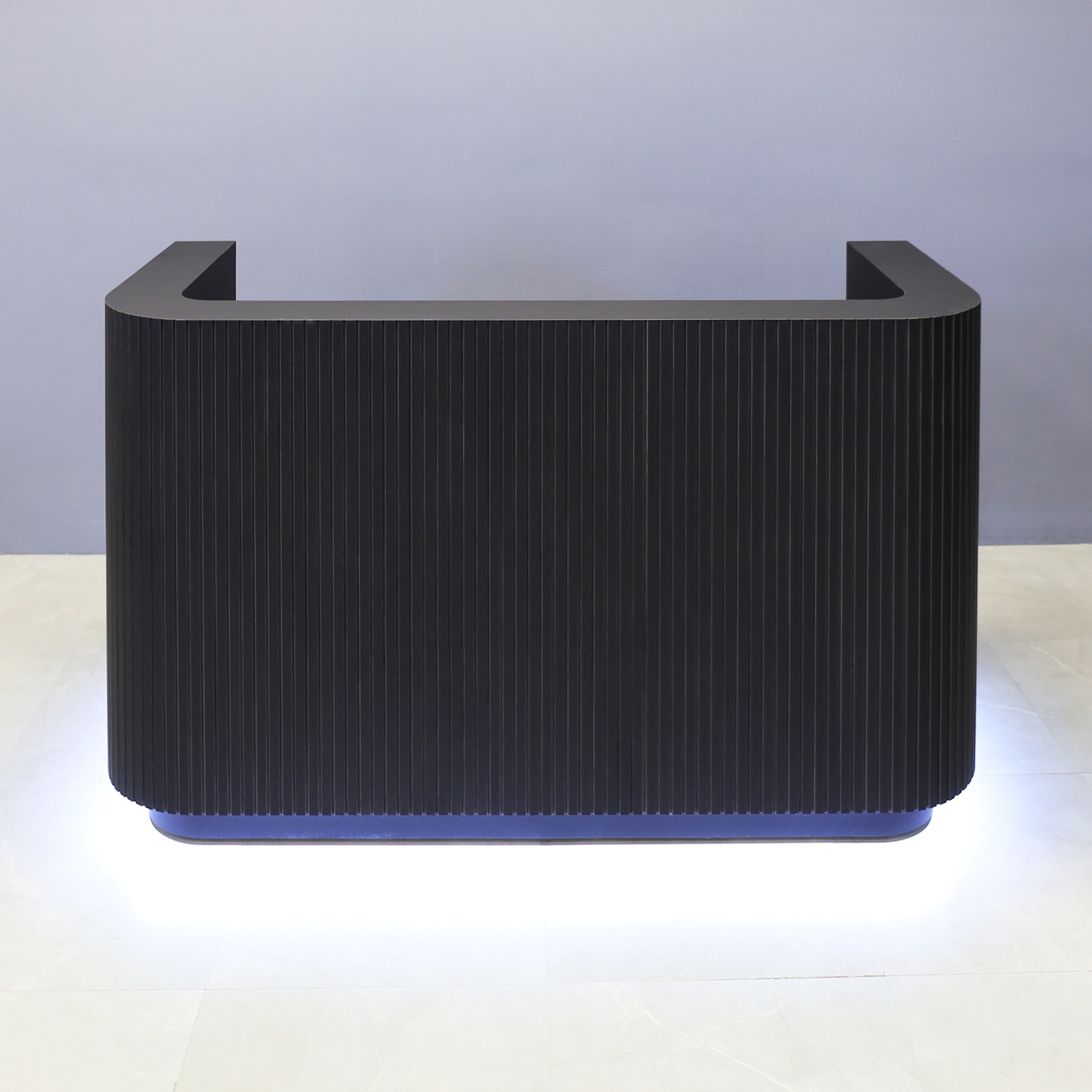72-inch Nola Custom Reception Desk in black traceless tambour main desk and black traceless laminate workspace and toe-kick, with warm white LED, shown here.