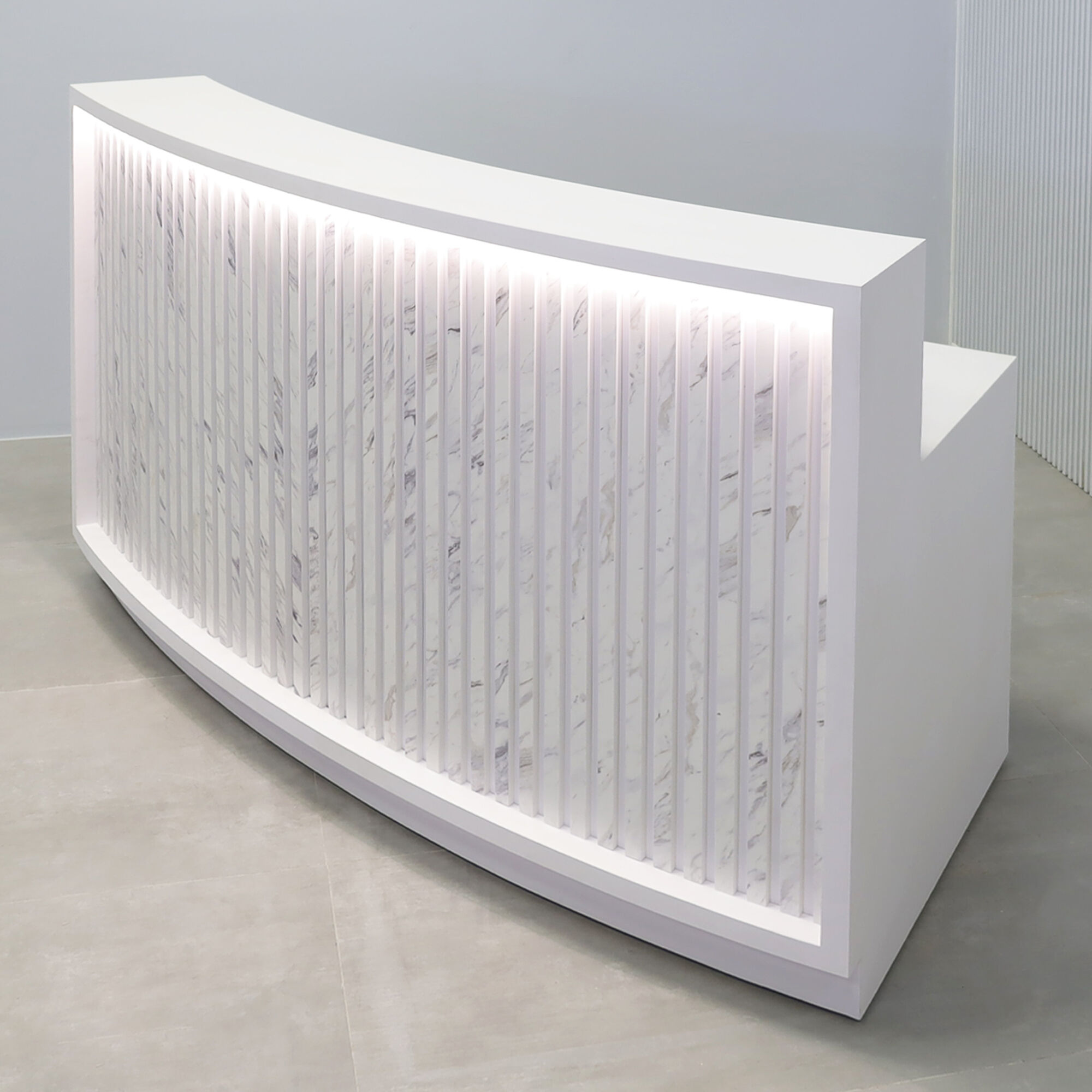 72-inch Seattle X2 Reception Desk in white matte PVC main desk, calcutta blanc engineered surface slats curved front panel, and warm white LED.
