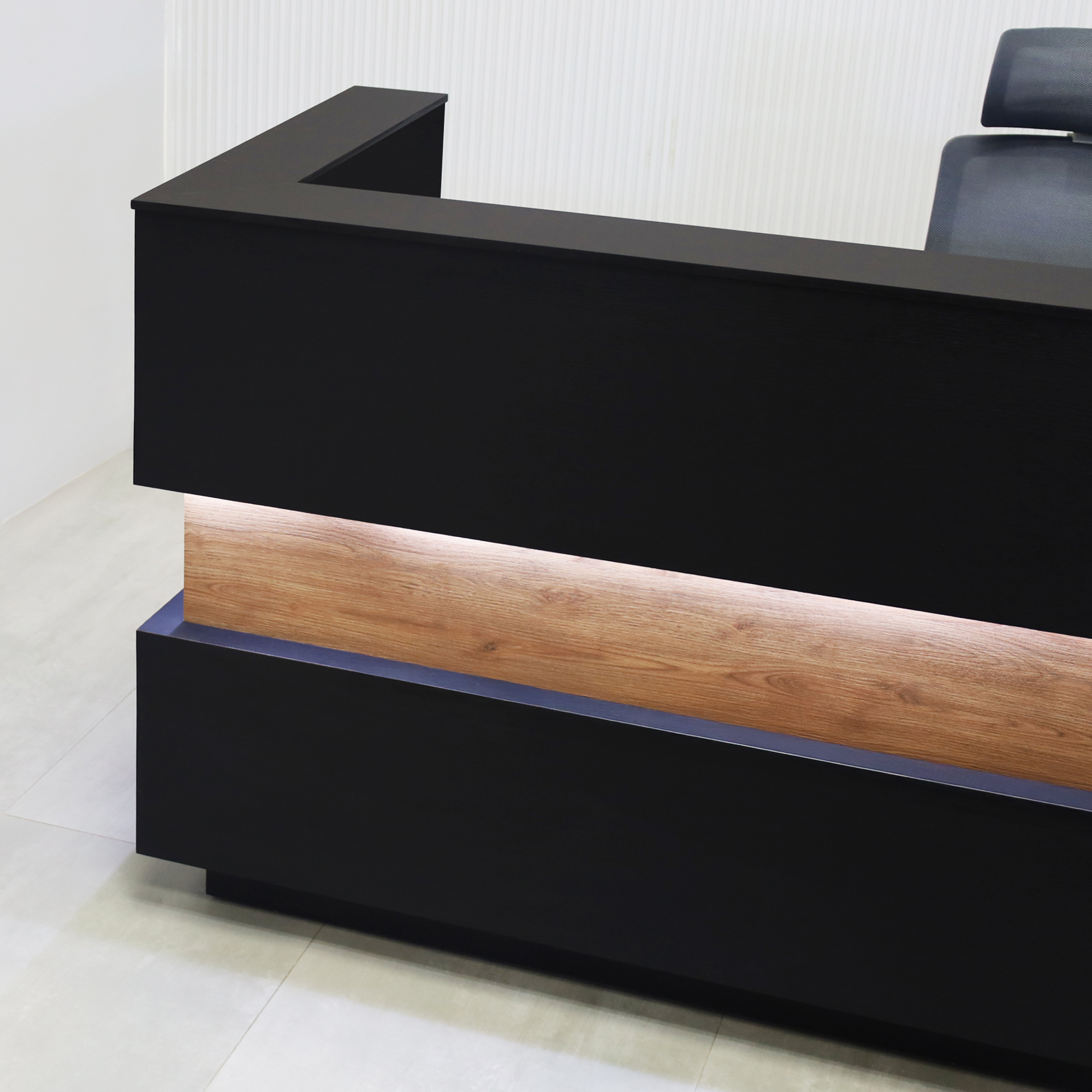 90-inch Pensacola Reception Desk with Black Cinder matte laminate desk and toe-kick. Spiced Chestnut laminate accent, Black traceless engineered surface top, and White LED.