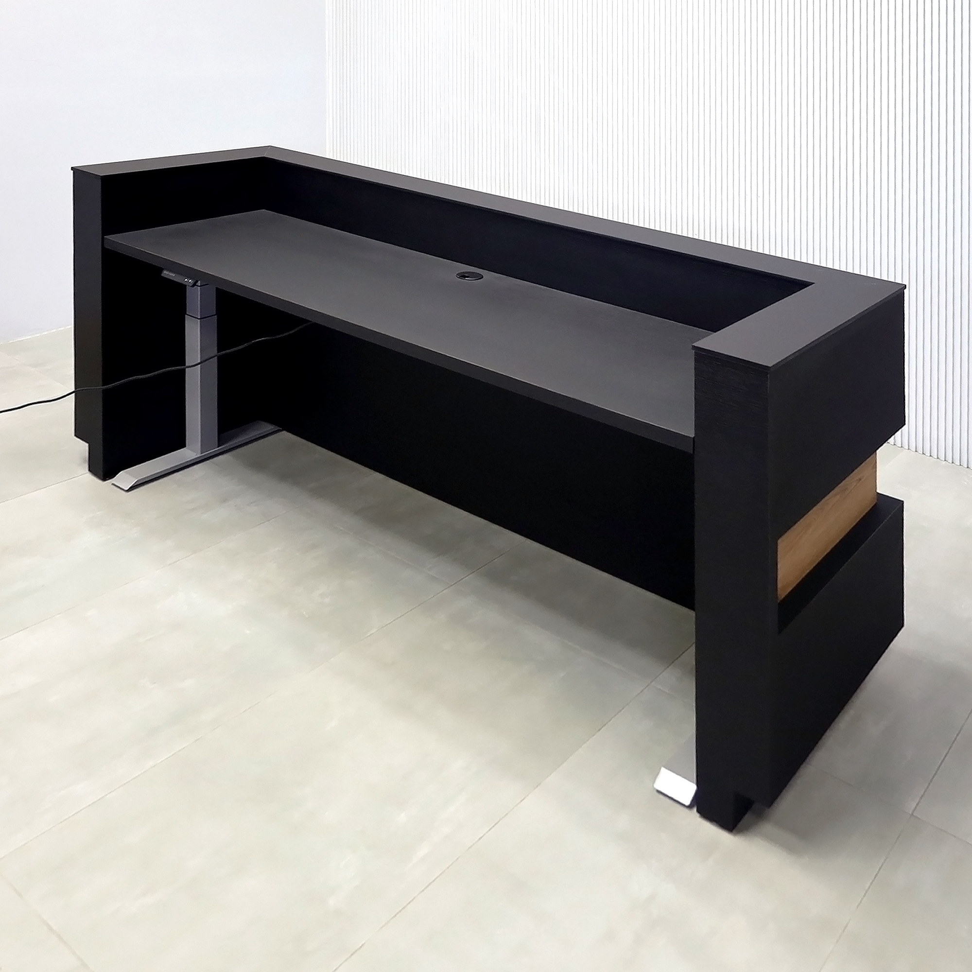 90-inch Pensacola Reception Desk with Black Cinder matte laminate desk and toe-kick. Spiced Chestnut laminate accent, Black traceless engineered surface top, and White LED.