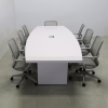 118 inches Newton Boat Shaped Conference Table in White Gloss Laminate top and base finish, and one Ellora power box with seven gray chairs shown here.