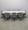 118 inches Newton Boat Shaped Conference Table in White Gloss Laminate top and base finish, and one Ellora power box with eight gray chairs shown here.