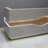 96-inch Wave Reception Desk in light gray gloss laminate desk and counter, zebrawood veneer wave accent front and brushed aluminum toe-kick, with warm white LED shown here.