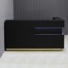 72-inch Manhattan L-Shape Custom Reception Desk in black traceless laminate accent panel & main desk, and gold aluminum toe-kick, with warm white LED, shown here.