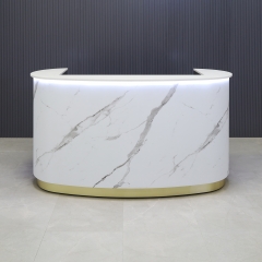 The Pill Custom Reception Desk with engineered stone top, calcutta stone pvc front panel, fog gray laminate workspace and brushed gold toe-kick, with white LED shown here.