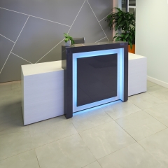 New York Extra Wide Custom Reception Desk in storm gray gloss laminate counter and front panel, and white ash laminate desk, with multi-colored LED shown here.